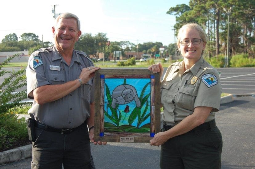 Volunteer and CSO Board member, Nills Anderson presents his stained glass portrait of Rosie, the manatee to Park Manager Kimberlee Tennille.